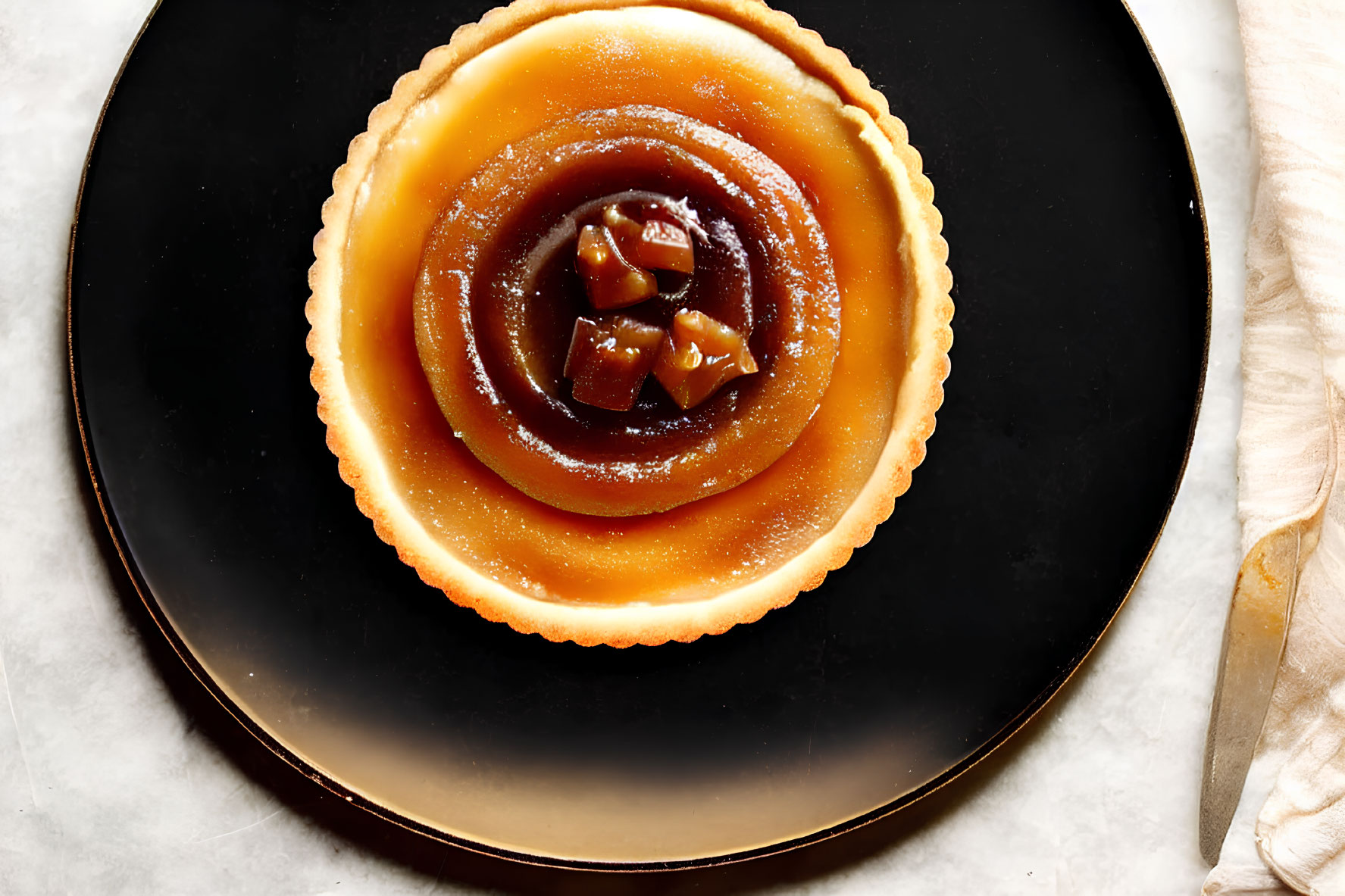 Caramel Tart with Fluted Edge on Black Plate