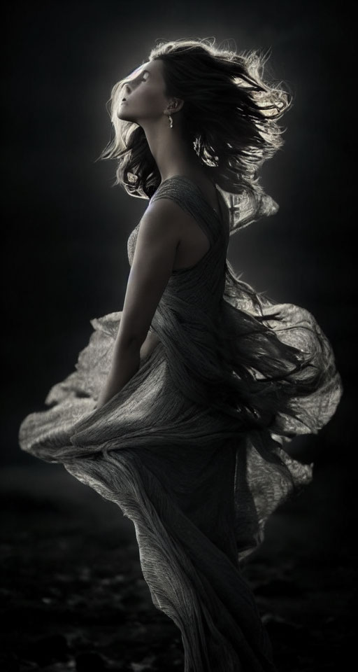 Elegant woman in flowing gown against moody backdrop