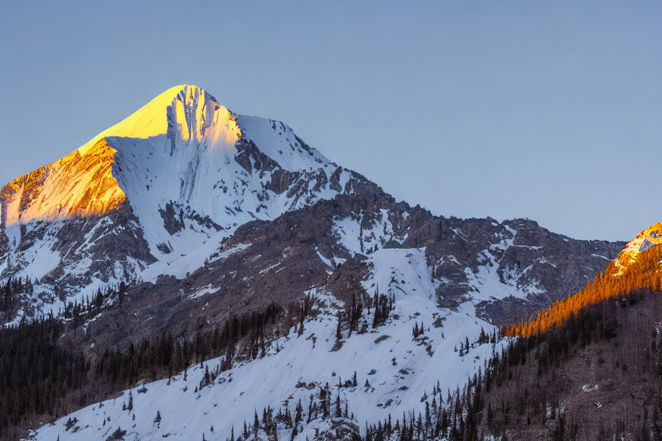 Snow-Capped Mountain Peak at Sunrise with Blue Sky