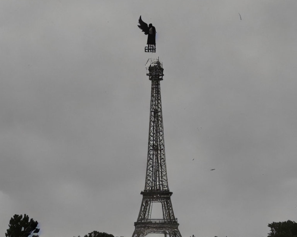 Bird on Eiffel Tower model in cloudy field