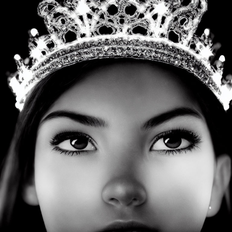 Sparkling crown worn by a person, close-up shot against dark background