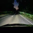 Nighttime road scene with illuminated lane markings and dark surroundings