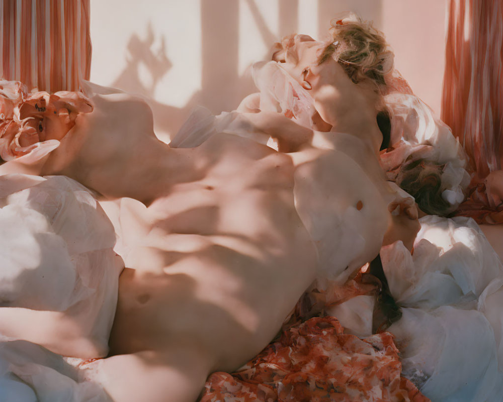 Person lying on bed with messy white and pink bedding in soft, warm light.