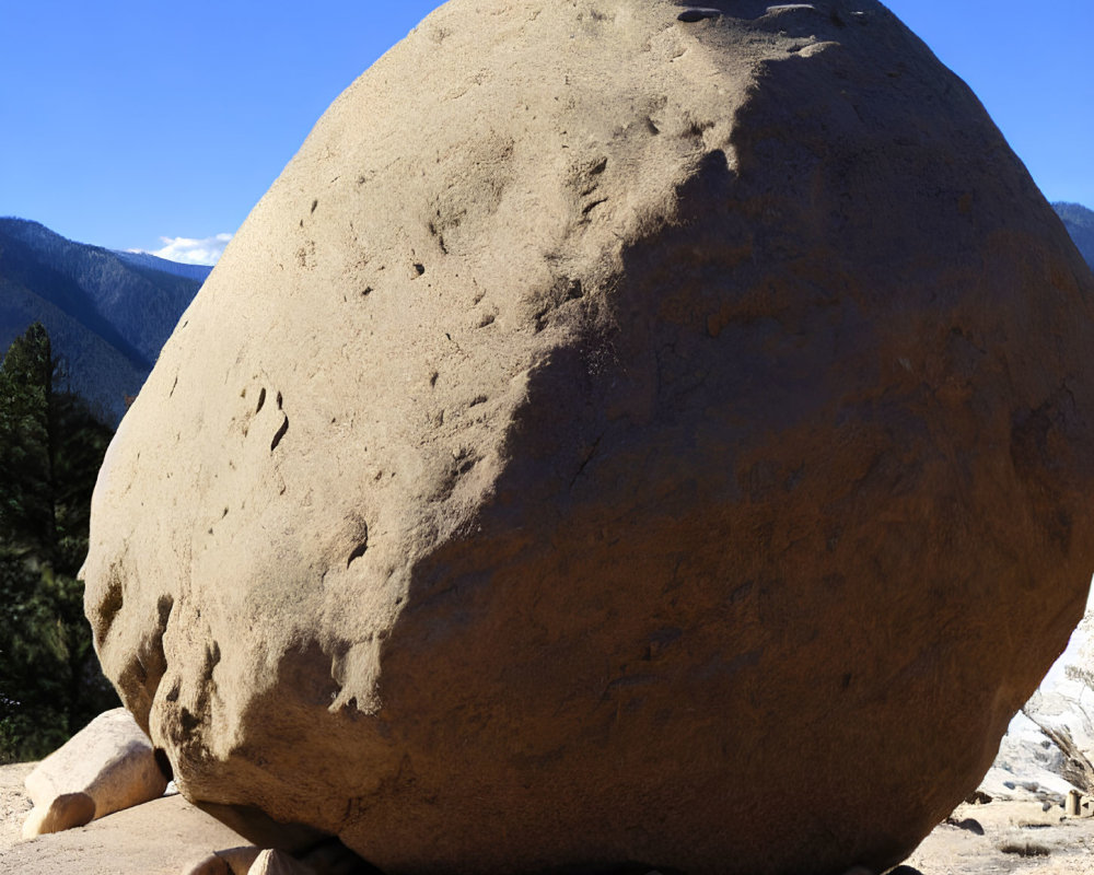 Prominent round boulder against mountainous backdrop