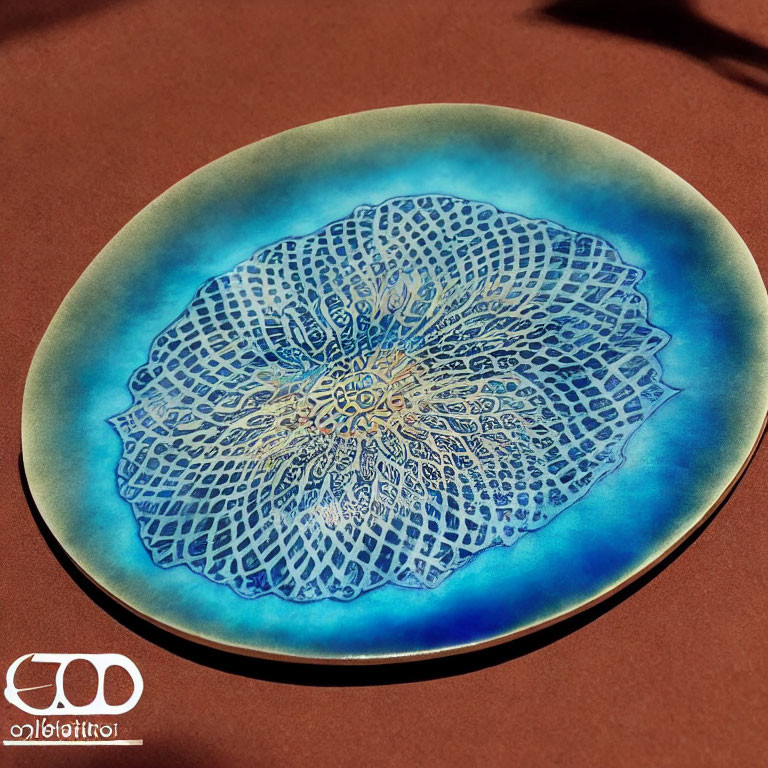Blue Gradient Ceramic Plate with White Mandala Design on Red Surface