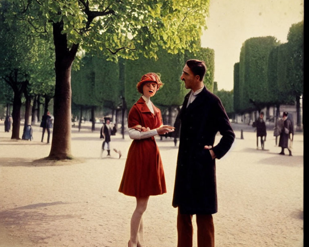 Man in Coat and Woman in Red Dress Talking on Tree-Lined Path