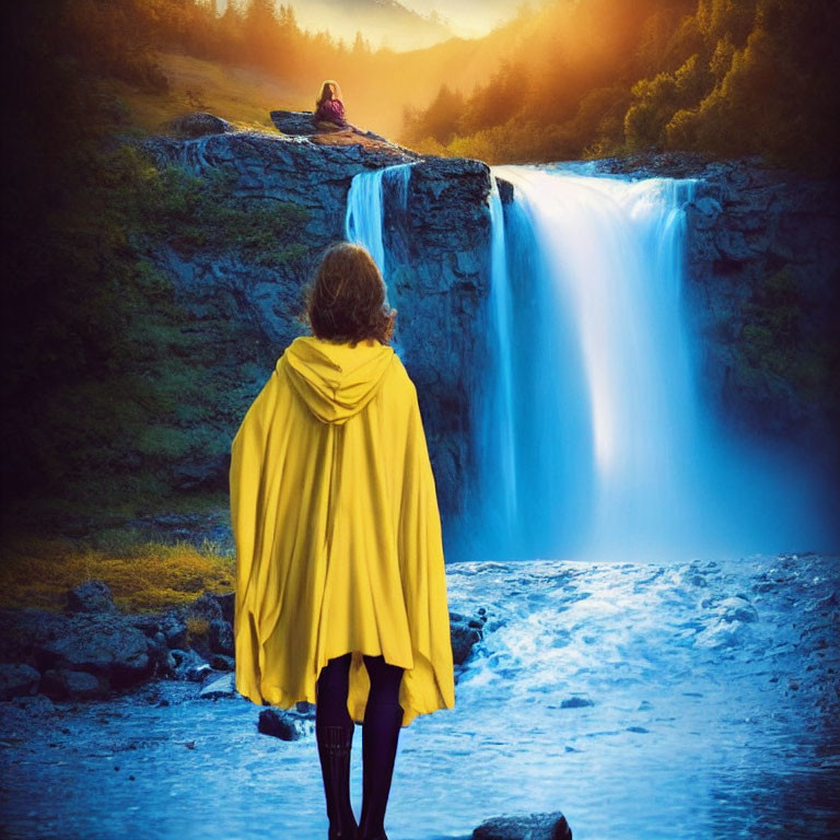 Person in Yellow Cloak Facing Majestic Waterfall at Sunset