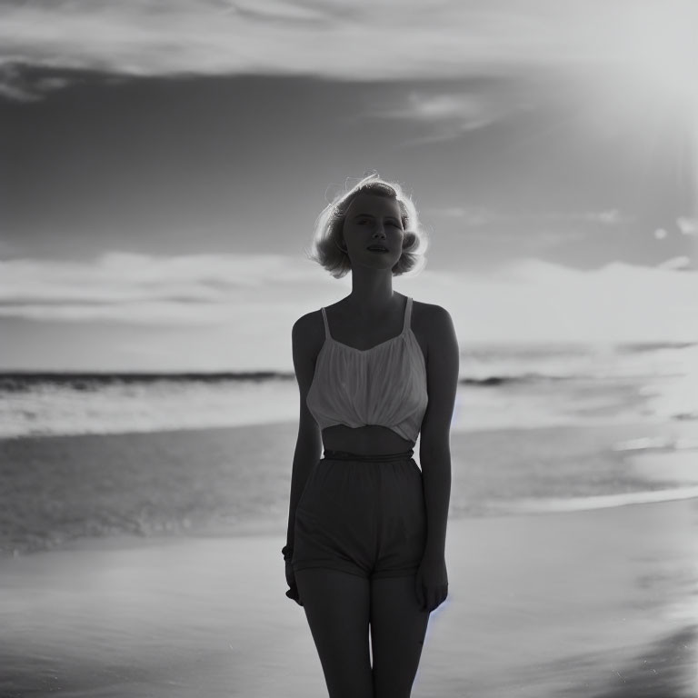 Monochrome image of woman on beach at sunset