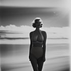 Monochrome image of woman on beach at sunset
