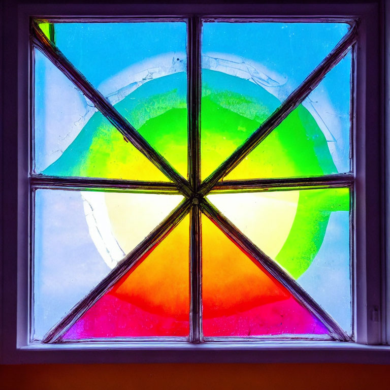 Vibrant geometric stained glass window against blue sky