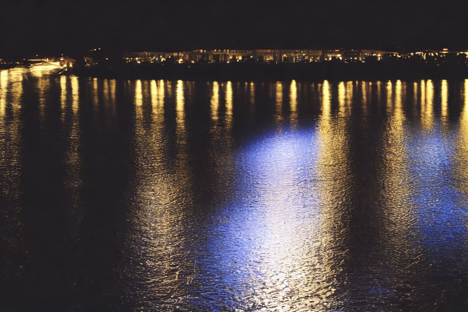 Tranquil night scene with shimmering lights reflecting on water