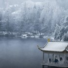 Snow-covered trees and calm lake in tranquil winter scene