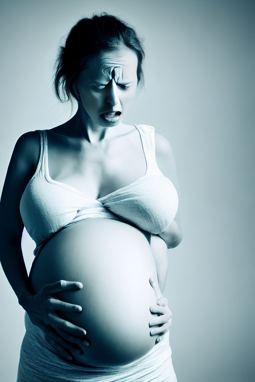 Pregnant Woman Holding Belly with Pained Expression in Cool Blue Tone