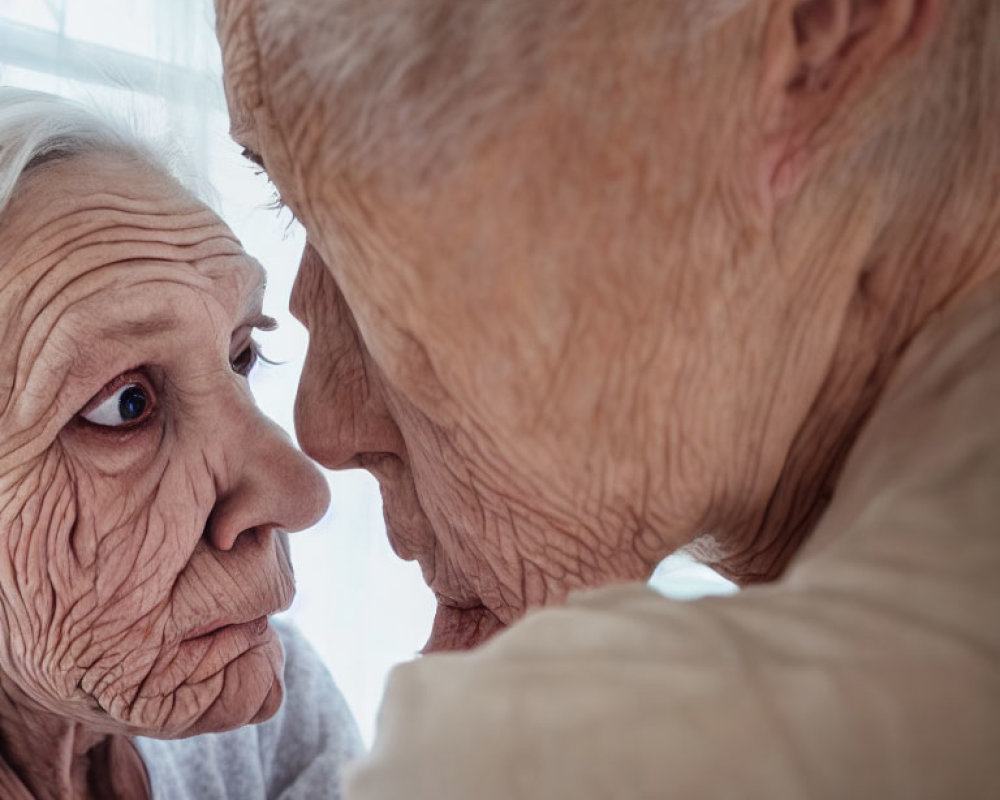 Elderly individuals touching foreheads intimately