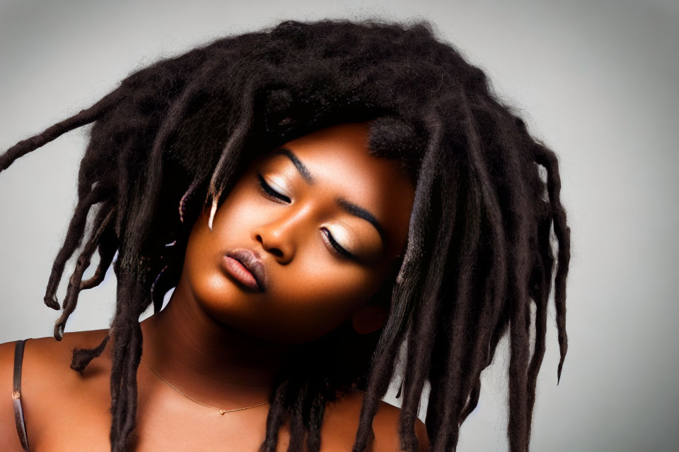 Woman with Long Dreadlocks in Calm Pose on Grey Background
