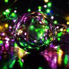 Colorful Christmas Baubles on Glittery Surface with Bokeh Lights