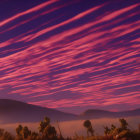 Twilight sky with pink and purple streaked clouds over mountains and trees