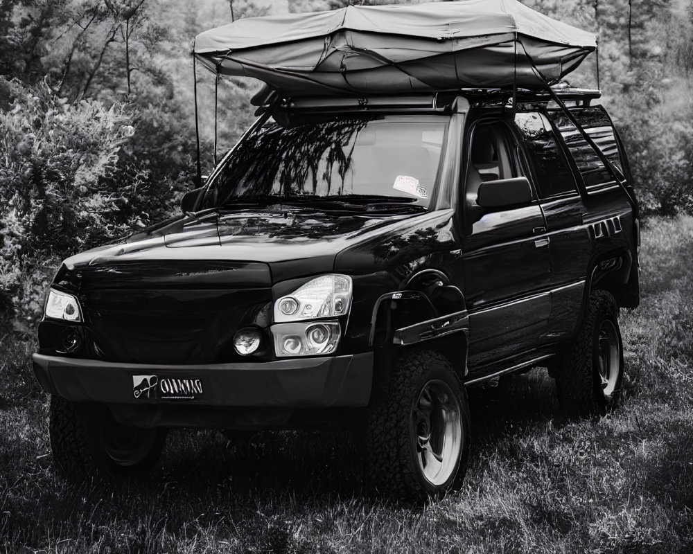 Black off-road vehicle with roof-top tent in forested area for outdoor adventure.