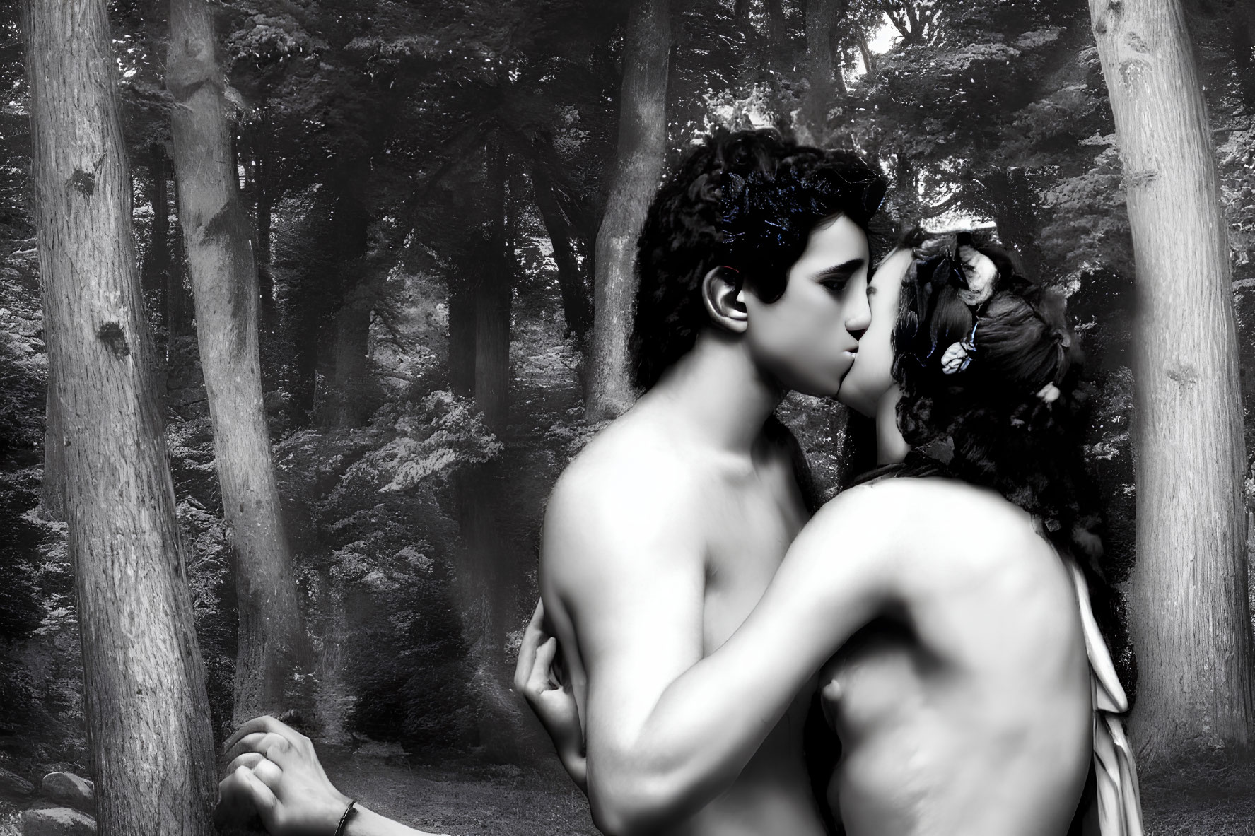 Monochrome image of shirtless man and woman embracing in misty forest