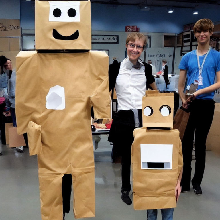 Two homemade cardboard robot costumes with a smiling person