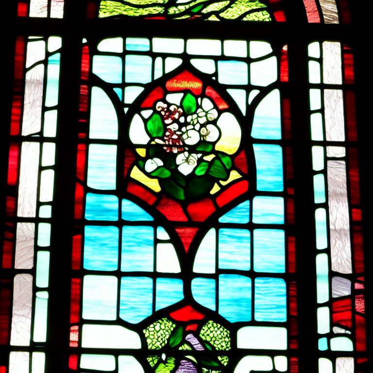 Colorful floral stained glass window in red, green, and blue