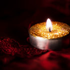 Golden diya with flickering flame and swirling patterns on dark background