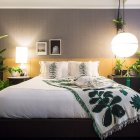 Floral wallpaper bedroom with double bed and plants