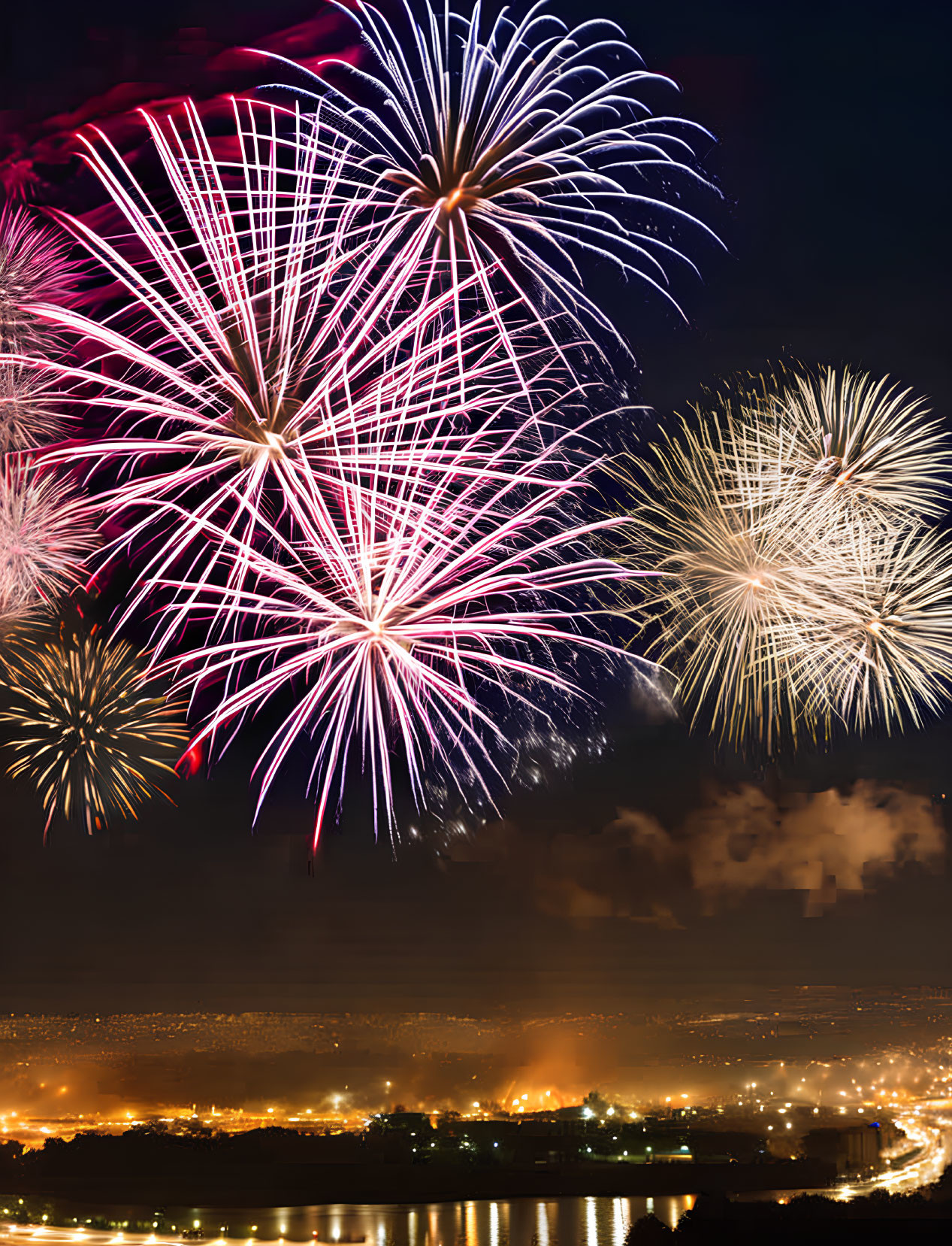 Colorful fireworks light up city night sky in purple, blue, and gold burst.