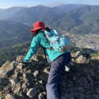 Climber in Hat Reaches Summit with Valley View