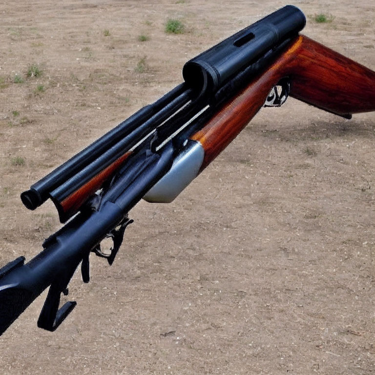 Close-up shotguns with wooden stocks on gravel background