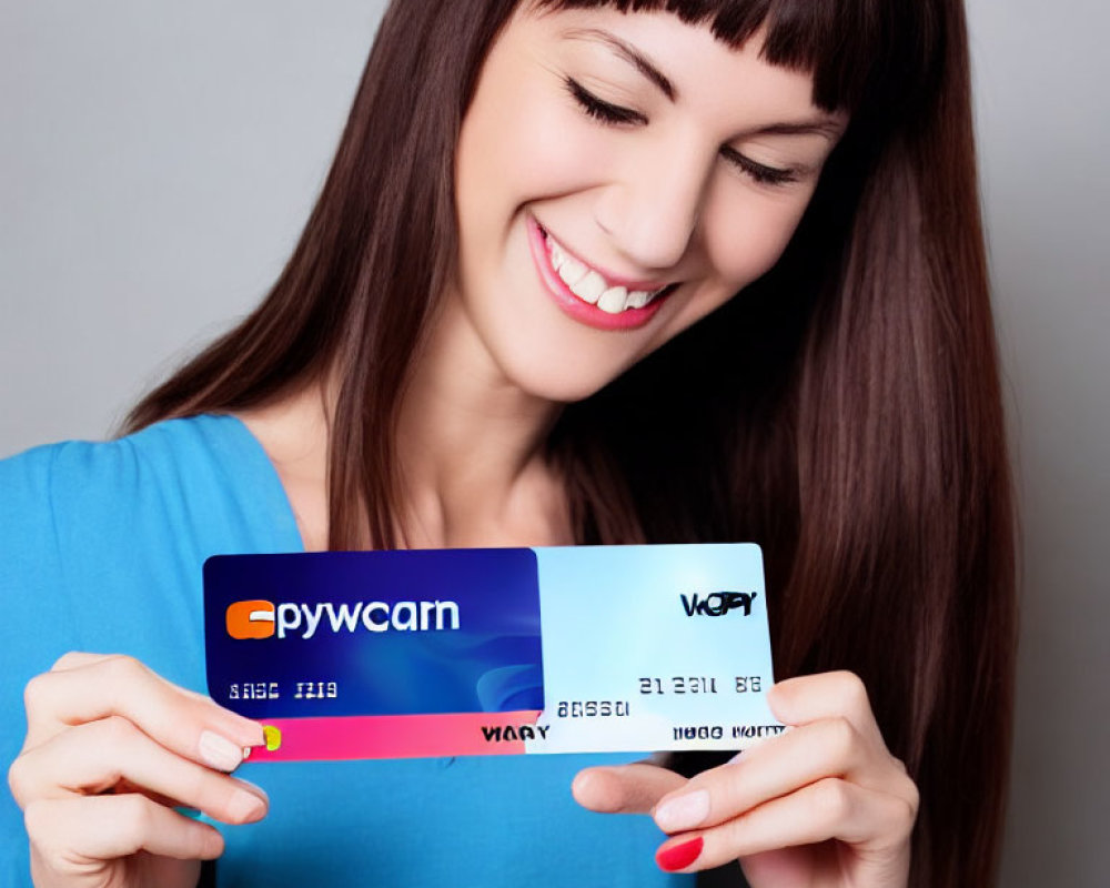 Smiling woman holding blue and white credit cards