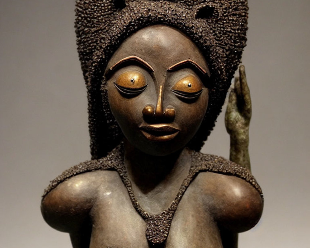 Intricately carved African wooden statue of female figure with elaborate hairstyles and textured surface