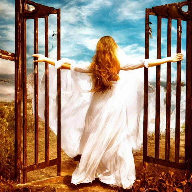 Woman in flowing white dress between open metal gates in scenic landscape