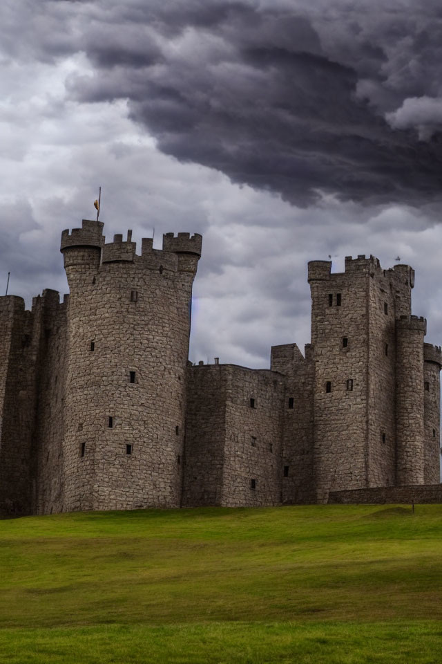Medieval castle with stone towers under dramatic cloudy sky