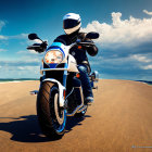 Person in White Helmet Riding Blue Motorcycle on Sandy Beach