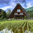 Majestic landscape with greenery, waterfalls, rice terraces, traditional houses, and sunlight