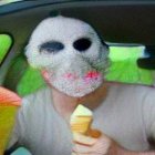 Person in car with face covered by soft serve ice cream holding ice cream cones