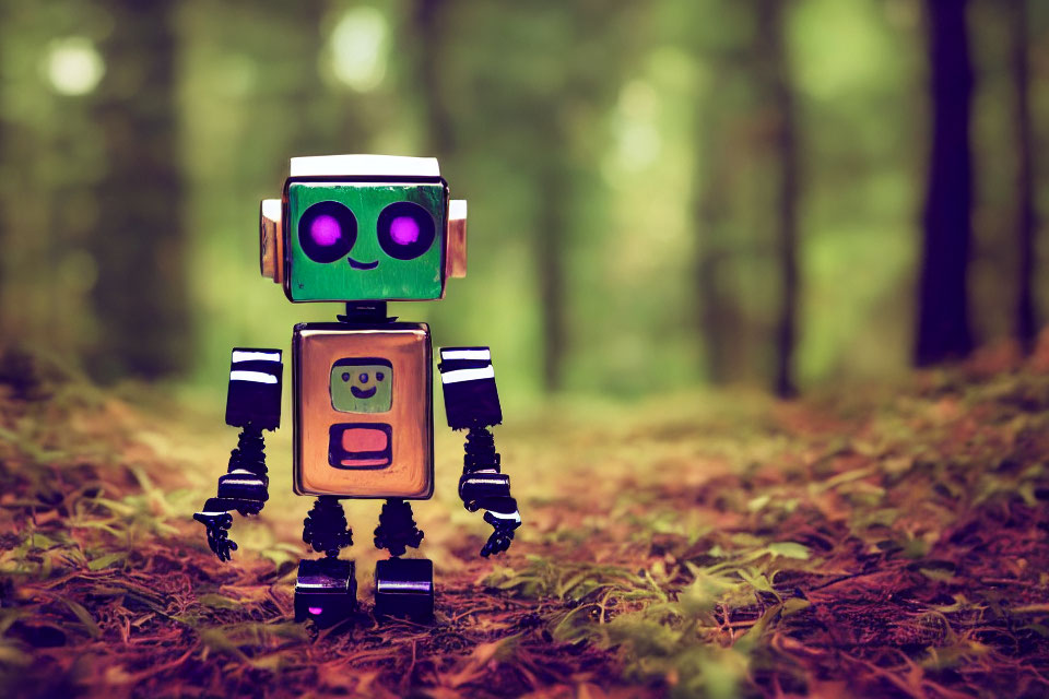 Green-eyed toy robot on forest floor with brown leaves and blurred trees