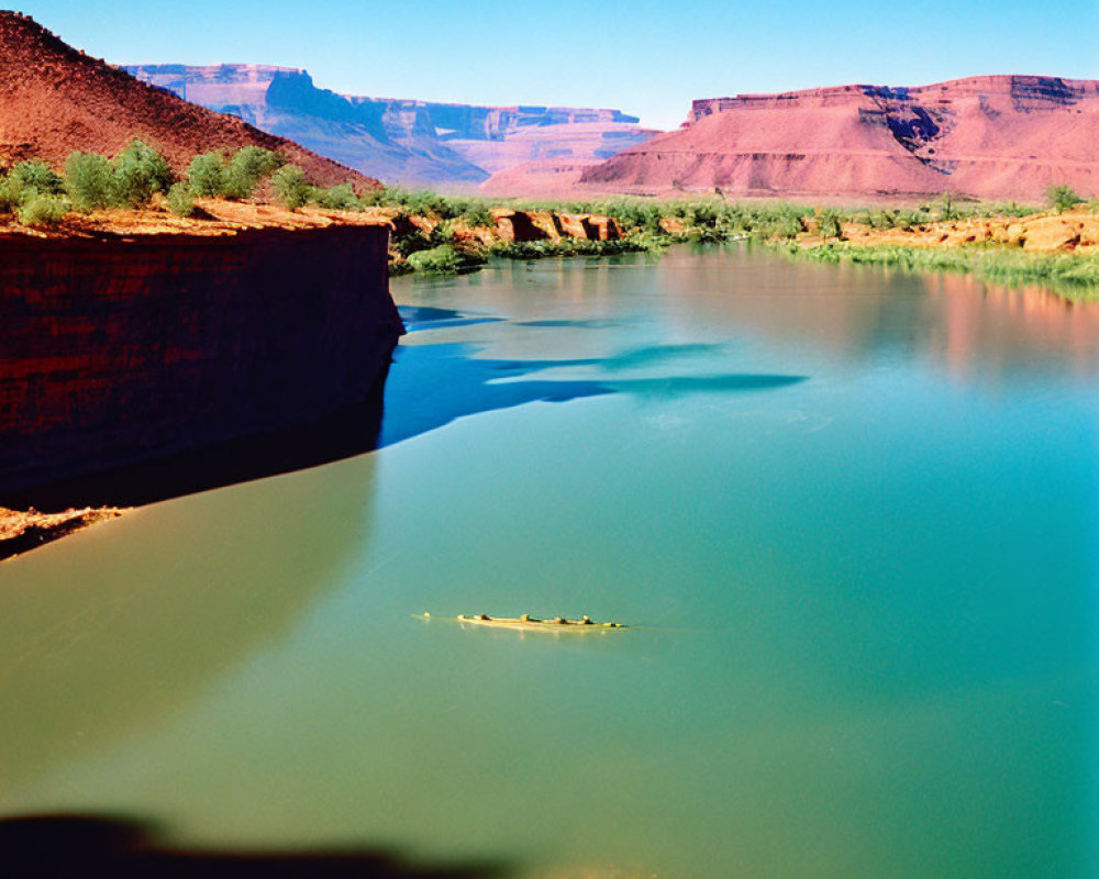 Tranquil river in red canyon with small boat