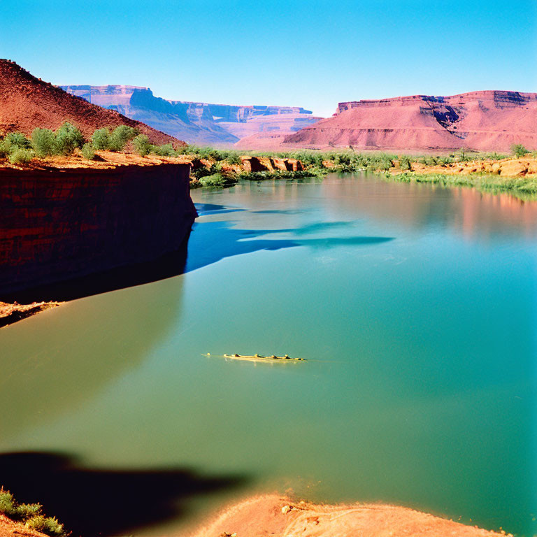 Tranquil river in red canyon with small boat