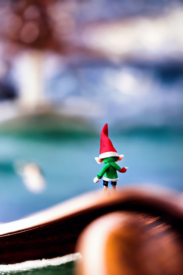 Small Gnome Figurine on Wooden Boat with Blurred Water Background