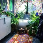 Stained glass windows, claw-foot tub, and mosaic tiles in a whimsical bathroom