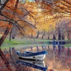Tranquil autumn lake landscape with blue boat and colorful foliage