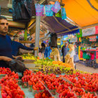 Colorful Fruit Market Scene with Smiling Vendor and Fresh Strawberries