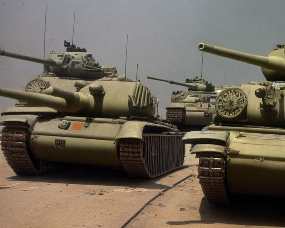 Lineup of Military Tanks on Sandy Terrain with Raised Gun Barrels