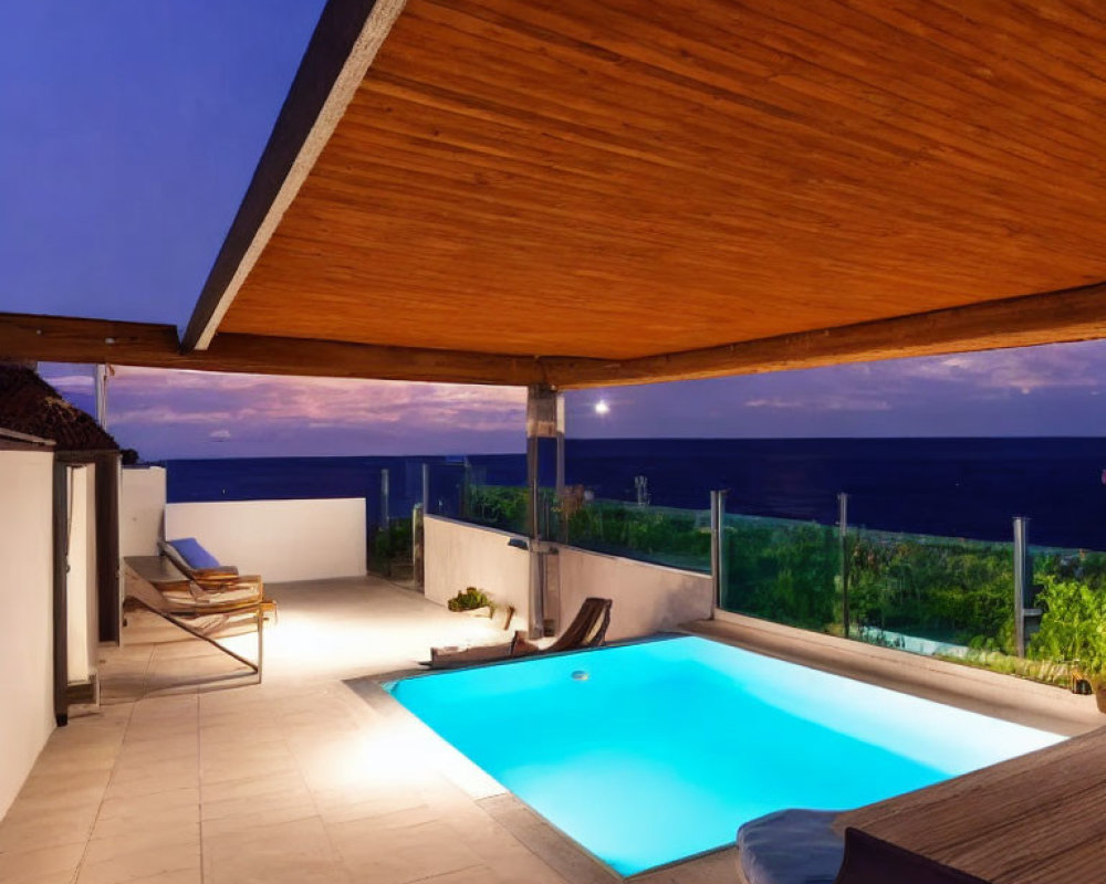 Modern outdoor pool area with ocean view at dusk, wooden overhang and loungers.