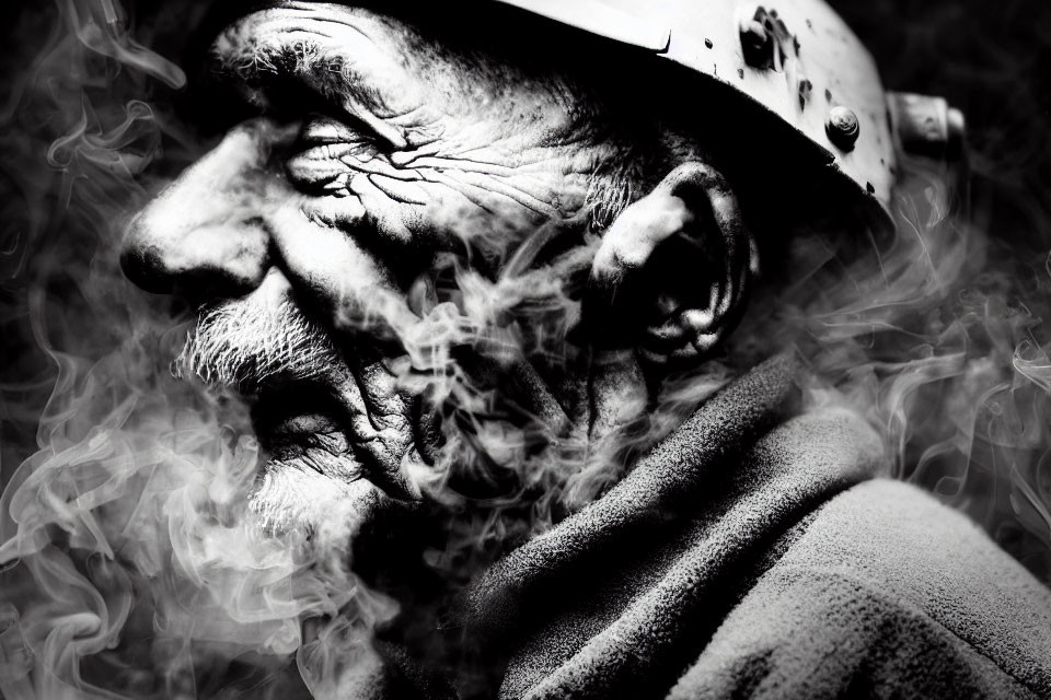 Elderly man in helmet with weathered face in black and white, surrounded by smoke