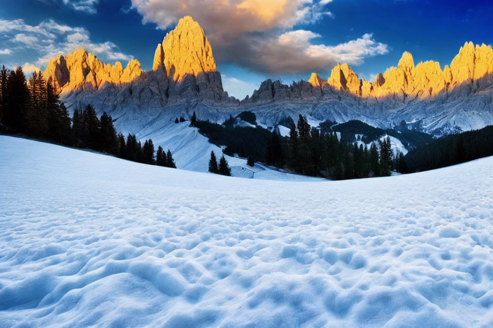 Snow-covered foreground and rugged mountain peaks in golden sunset light under a blue sky with scattered clouds