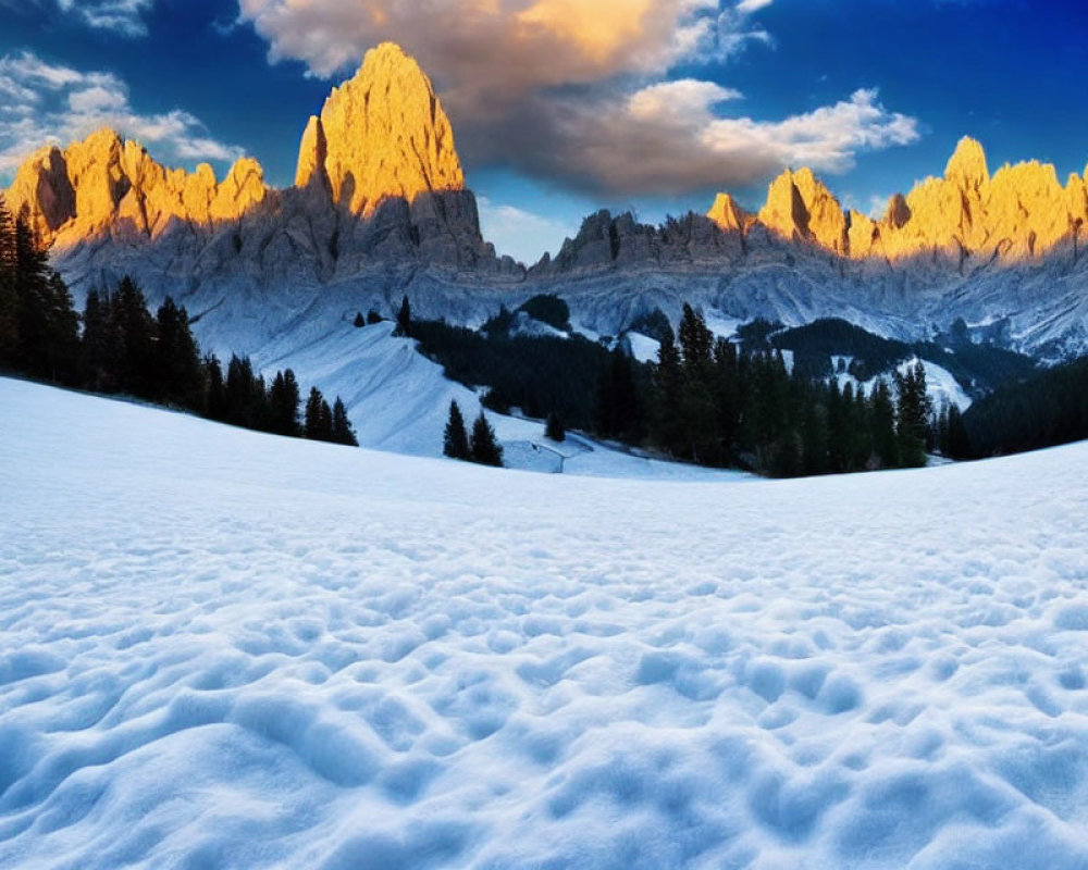 Snow-covered foreground and rugged mountain peaks in golden sunset light under a blue sky with scattered clouds
