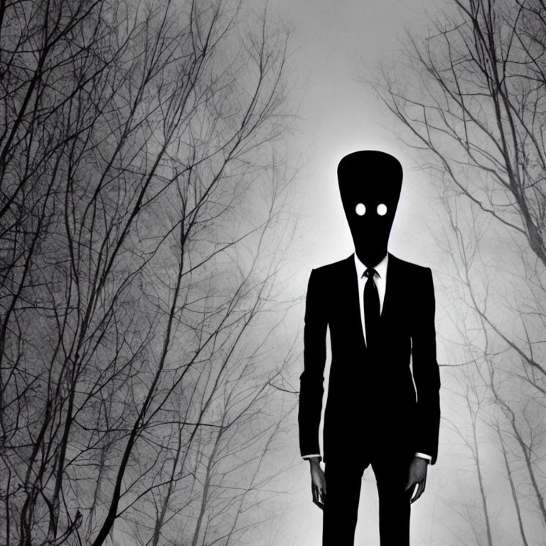 Monochrome image of figure with elongated head in suit, in misty forest